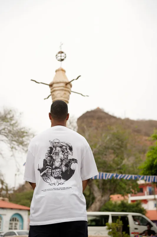 Back view of the shirt in a Cabo Verde town square by the historic pillory.